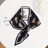 Small long strip silky scarf with floral pattern against a black background, perfect for stylish fashion accessorizing.