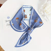 Small long strip silky scarf with floral pattern on blue background, versatile accessory for stylish women.