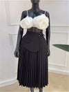 Elegant black pleated high waist split skirt paired with a stylish white floral top on a mannequin.