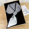 Small long strip silky scarf in a stylish black and white striped pattern, elegantly presented in a gift box.