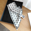 Small long silky scarf with polka dot pattern displayed in a box, elegant fashion accessory for women.