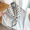 Elegant polka dot silky scarf tied around a white blouse, showcasing stylish design and versatility as a fashion accessory.